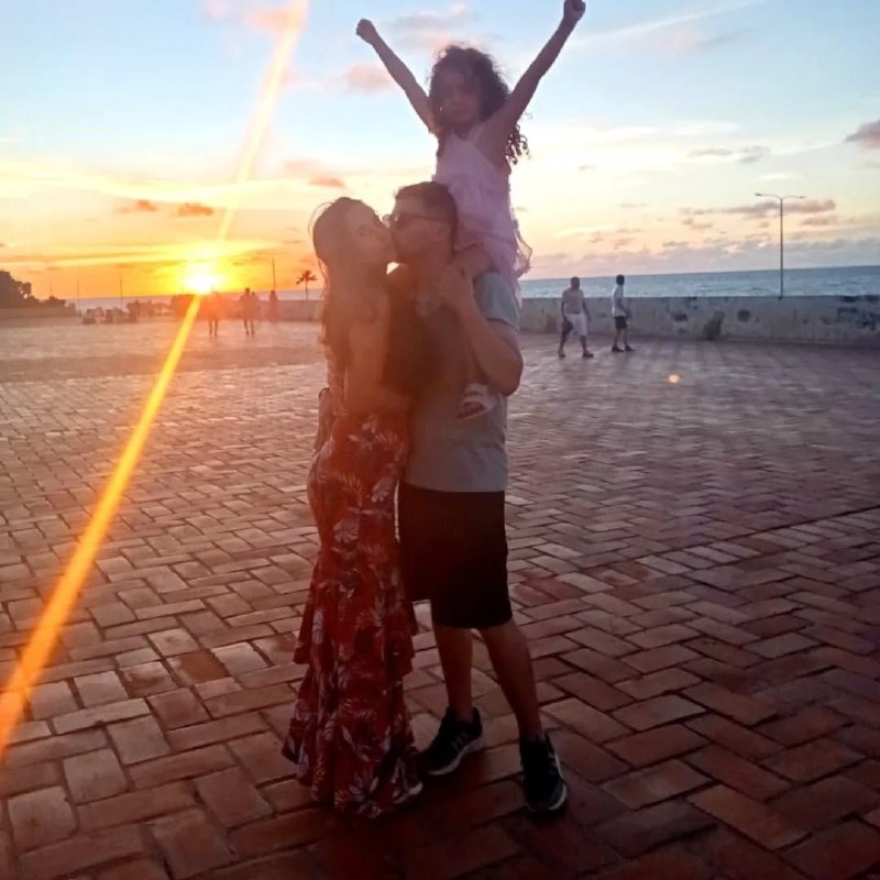 Los tres — padre, madre e hija — al atardecer en la costa colombiana